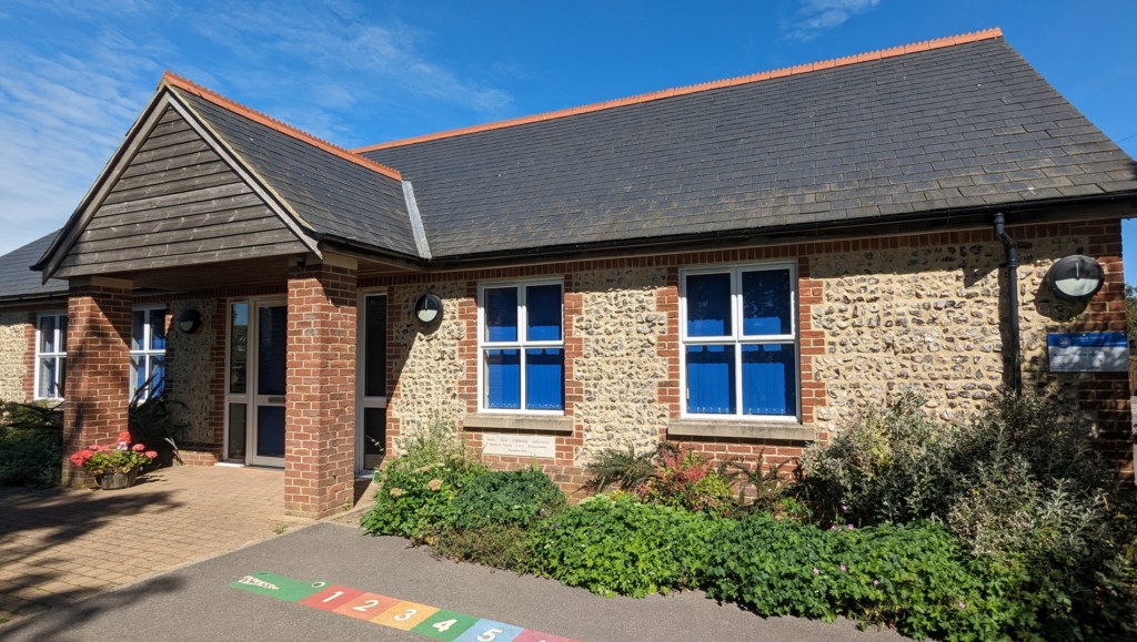 The plaque under the window reads - Family, Faith, Celebrating Achievment. - Baydon St. Nicholas Cof E Primary School - September 2010